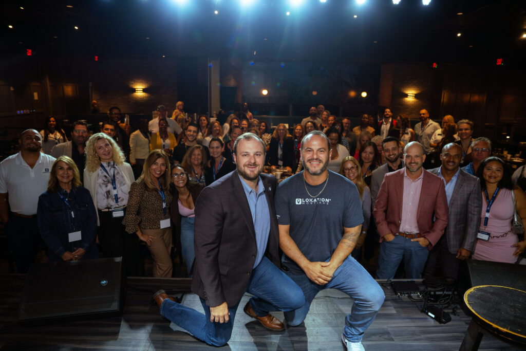 Nathan Klutznick and Jonathan Lickstein of LoKation Real Estate on stage with agents at a LoKation event