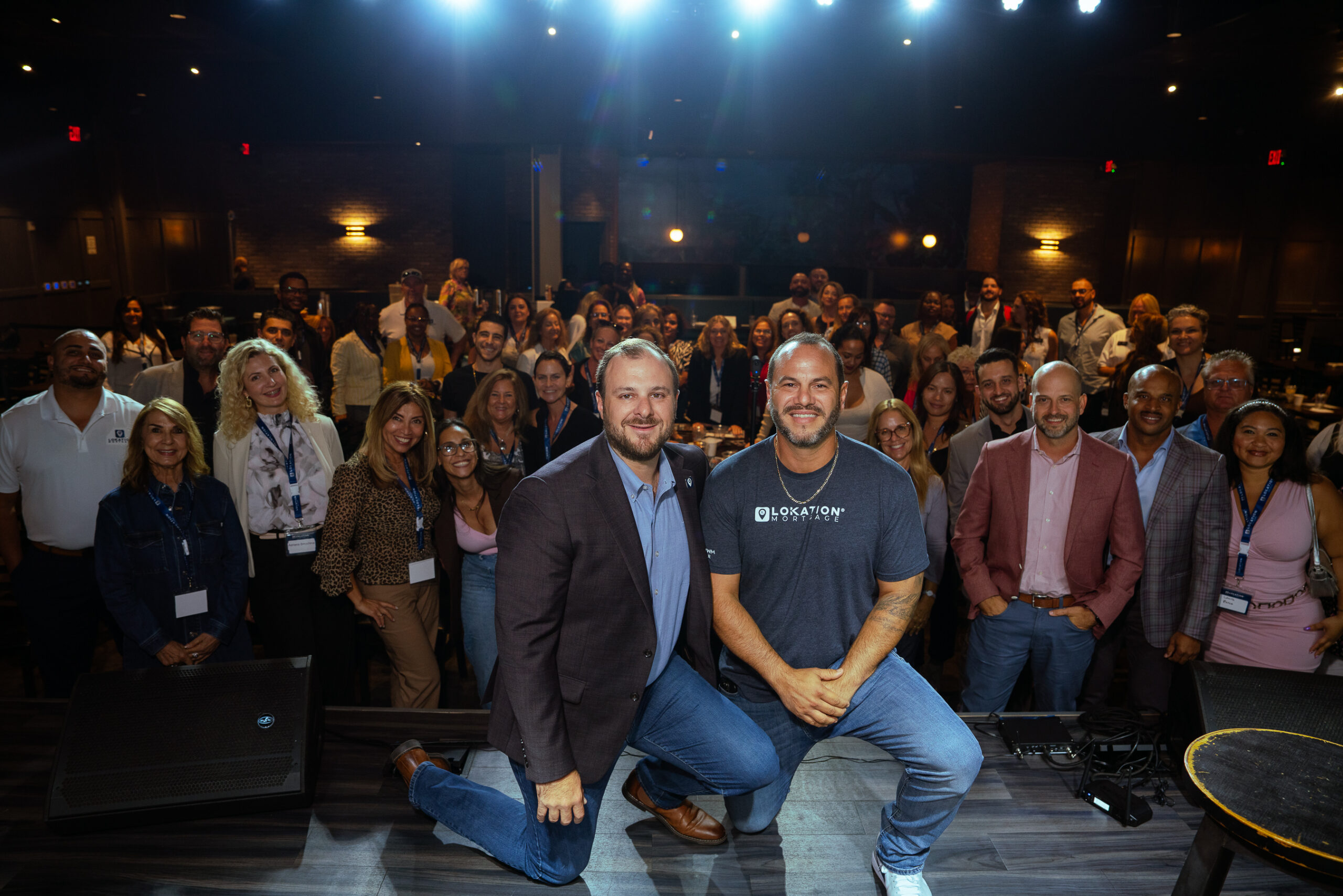 Nathan Klutznick and Jonathan Lickstein of LoKation Real Estate on stage with agents at a LoKation event
